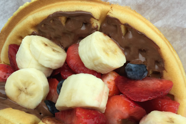 Waffle with Nutella spread, strawberries, blueberries and bananas