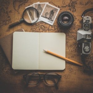 journal with camera, photos and magnifying glass