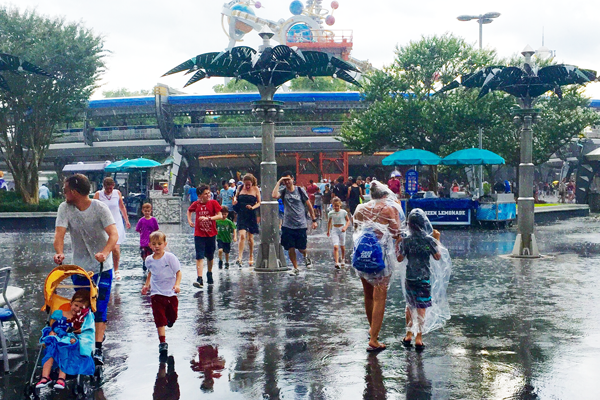 people walking in Magic Kingdom Tomorrowland in the rain