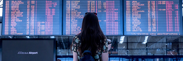 woman looking at flight departure board