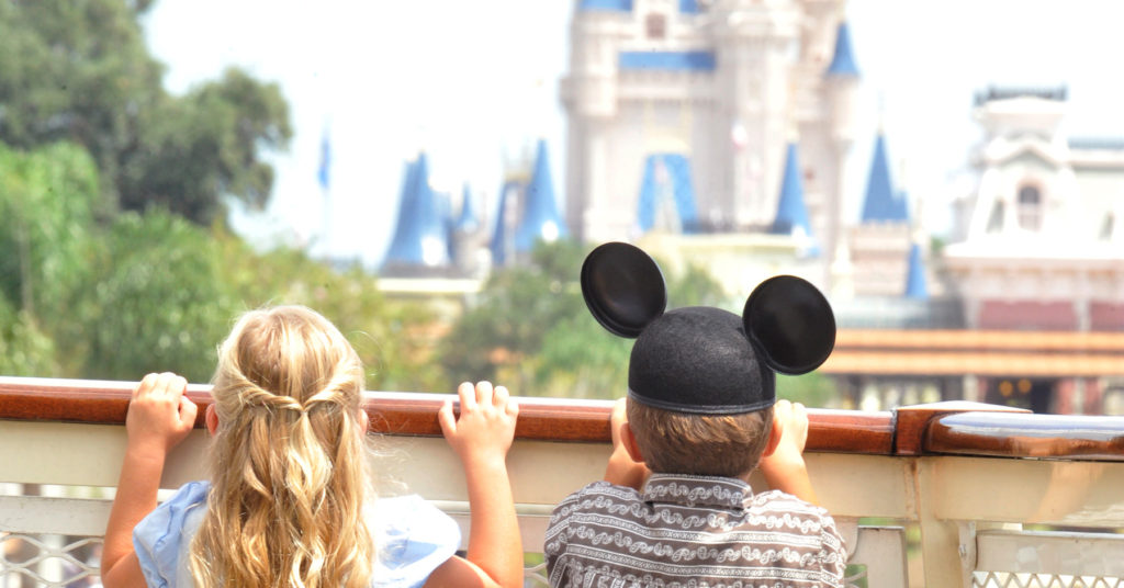 girl and boy in Mickey Mouse hat with ears looking at Cinderella's castle in Disney World Magic Kingdom