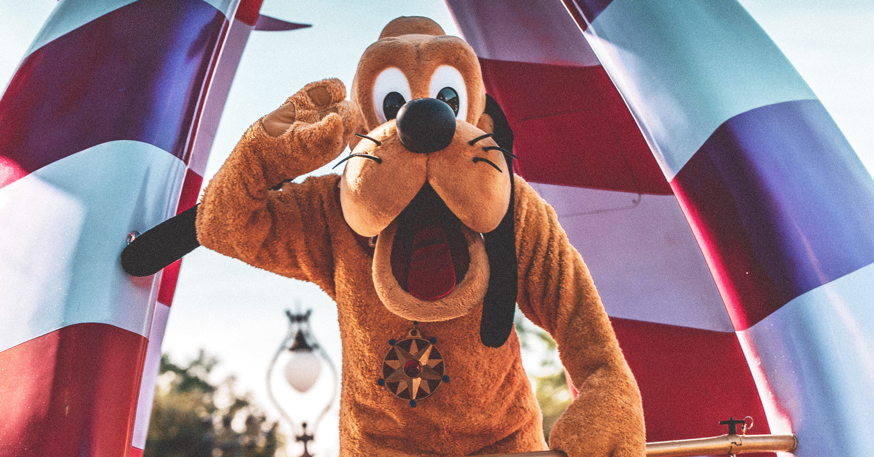 Disney's Pluto waving from parade float